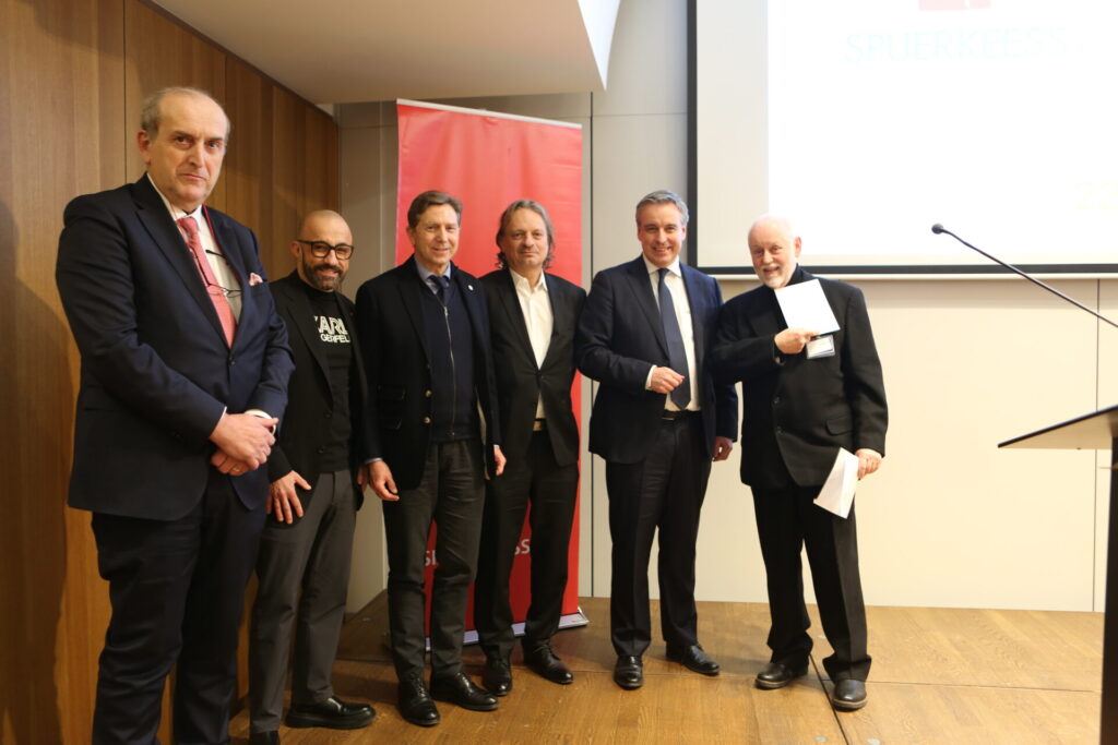 202501122 New Year Reception 46 Photo of 6 men in business attired, the man on the right is holding two pieces of paper. Pictured left to right Yves Stein, Stephane Di Carlo, David Arendt, Mario Di Stefano, Minister Claude Meisch, Paul Schonenberg